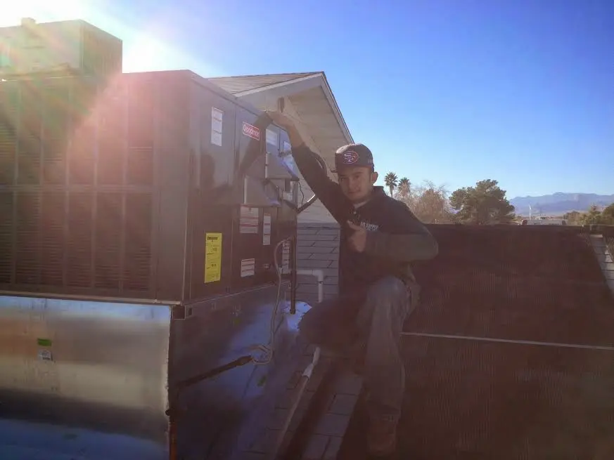 HVAC technician performing AC Tune-Up on a rooftop unit in Sunset